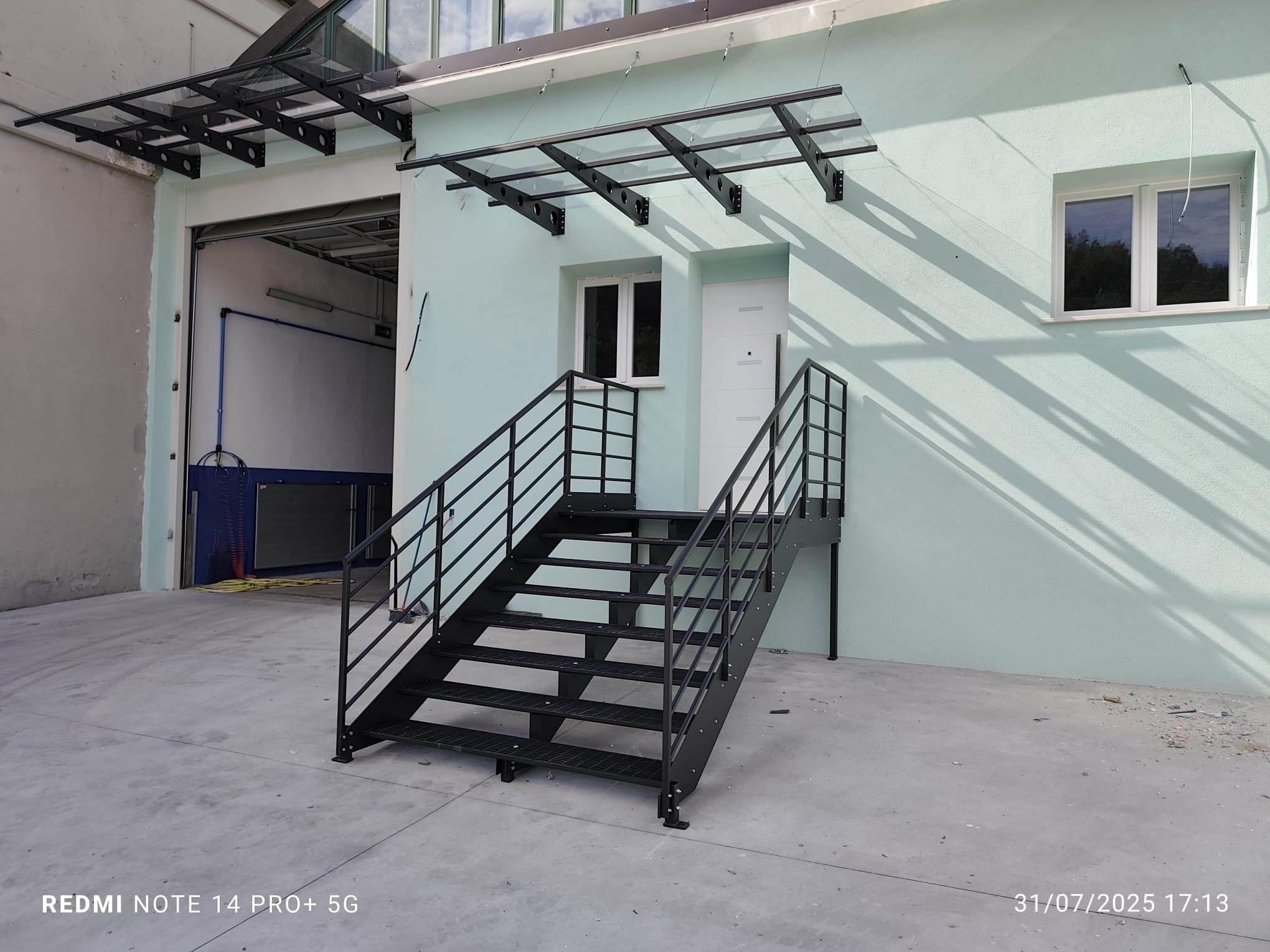 Scala esterna in metallo con tettoia e ringhiera realizzata da MZ Carpenterie